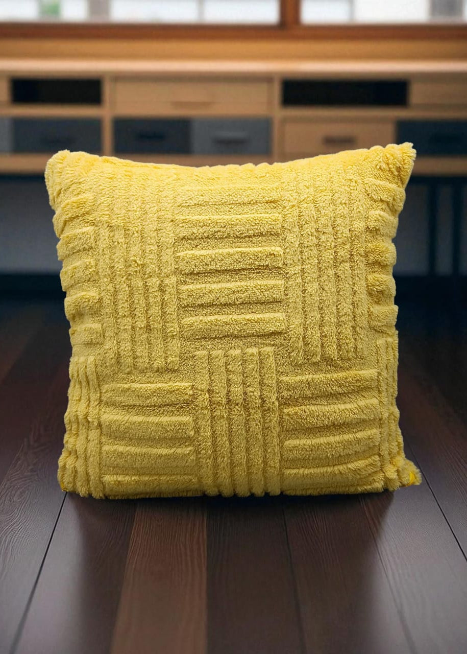 Yellow textured pillow on a wooden surface with a blurred background