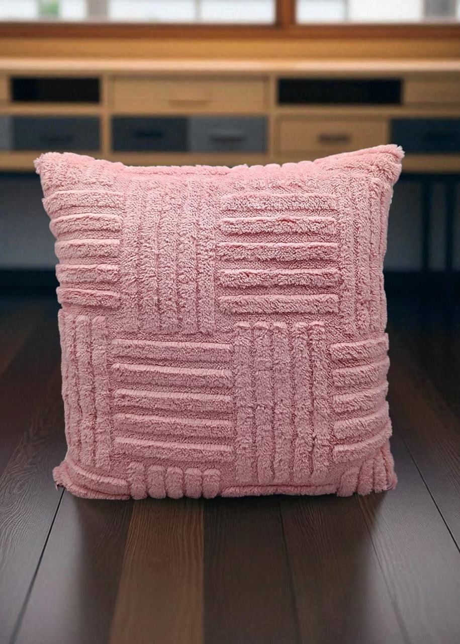 Pink textured pillow on a wooden surface with a blurred background
