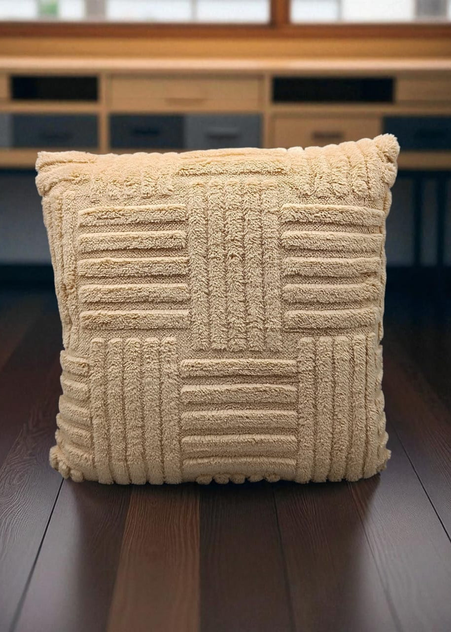Beige textured pillow on a wooden surface with a blurred background