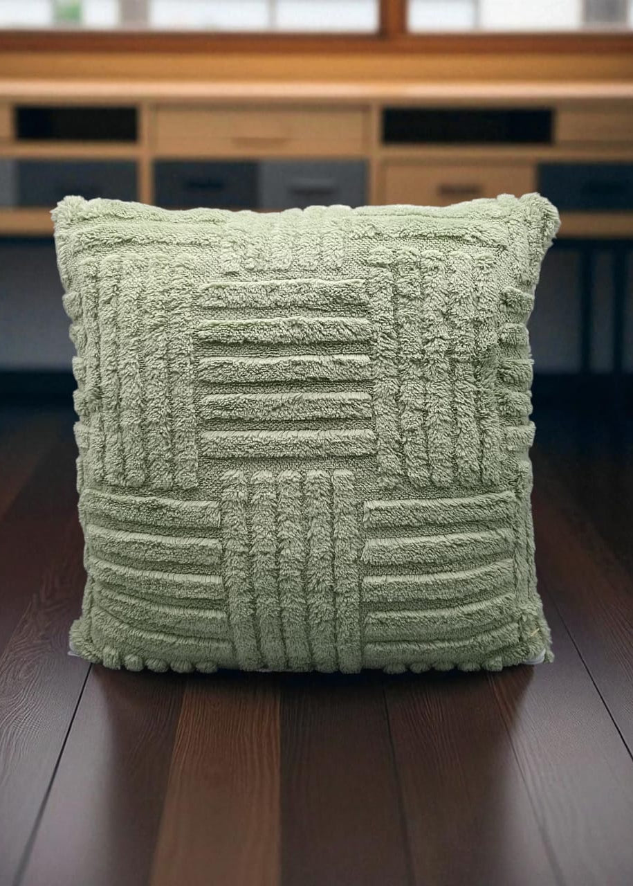 Green textured pillow on a wooden floor with a blurred background