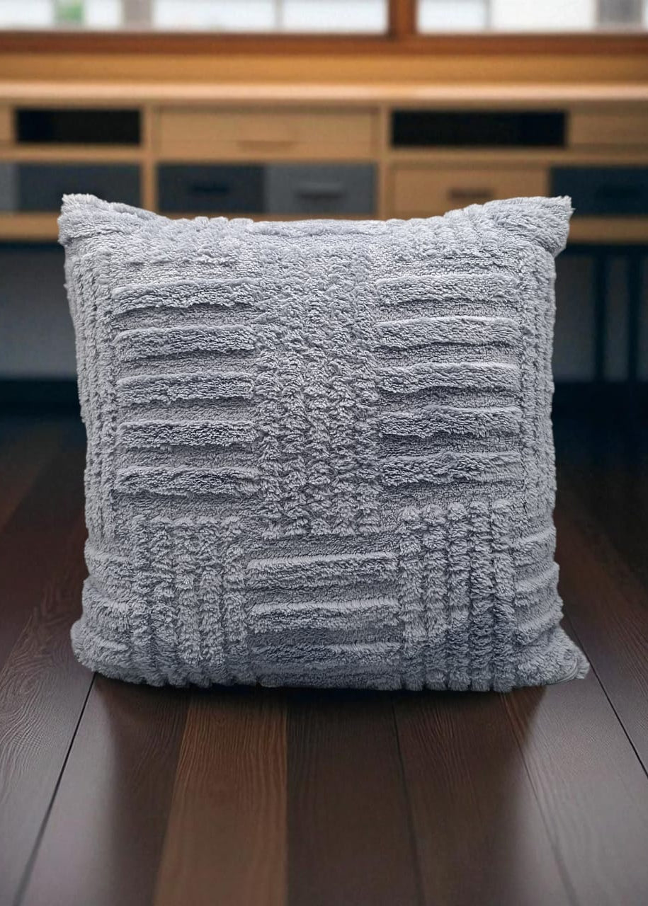 Textured gray pillow on a wooden surface with a blurred background