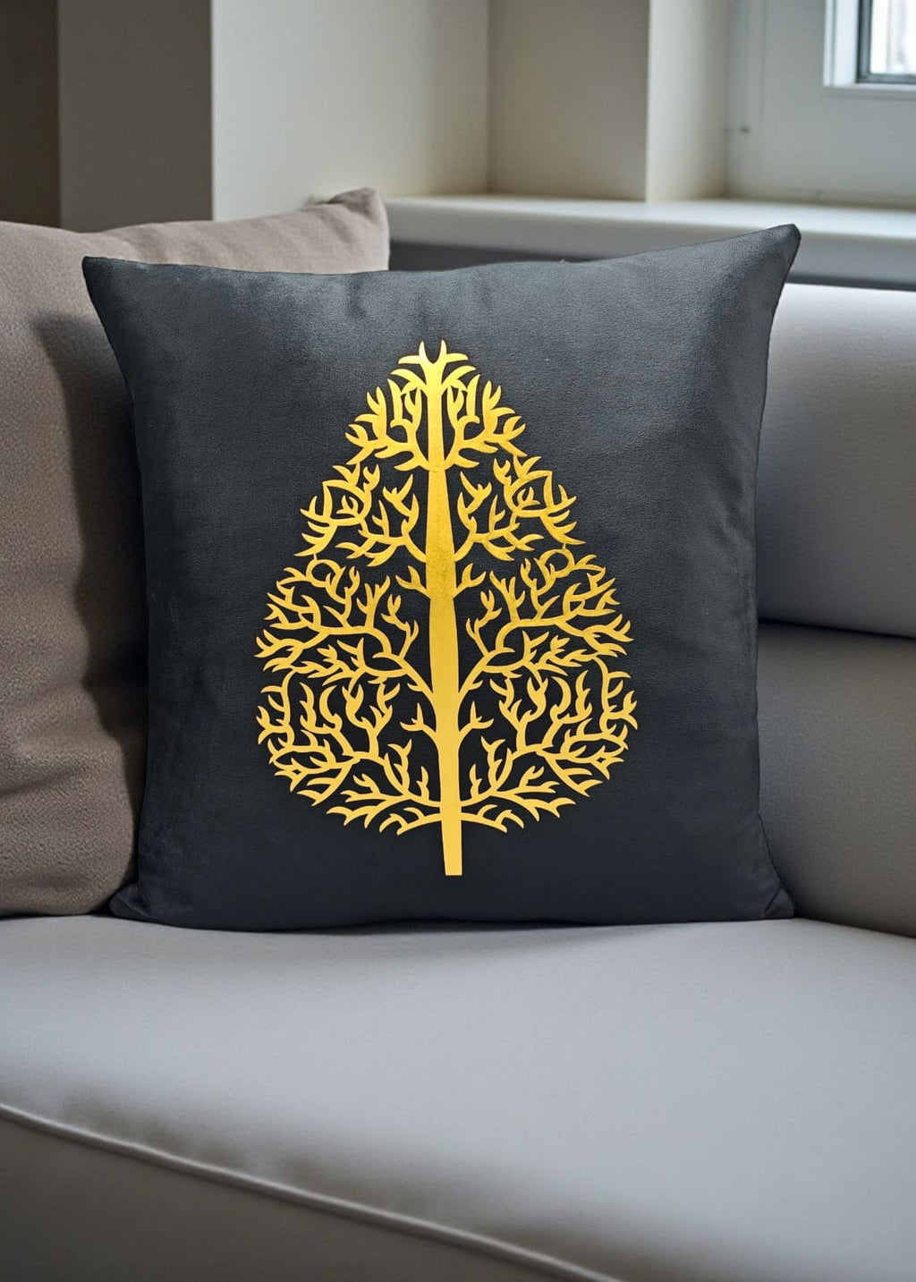 Gray pillow with a yellow tree design on a gray sofa