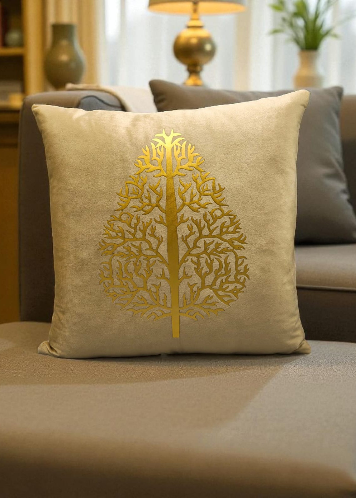 Beige pillow with gold tree design on a sofa