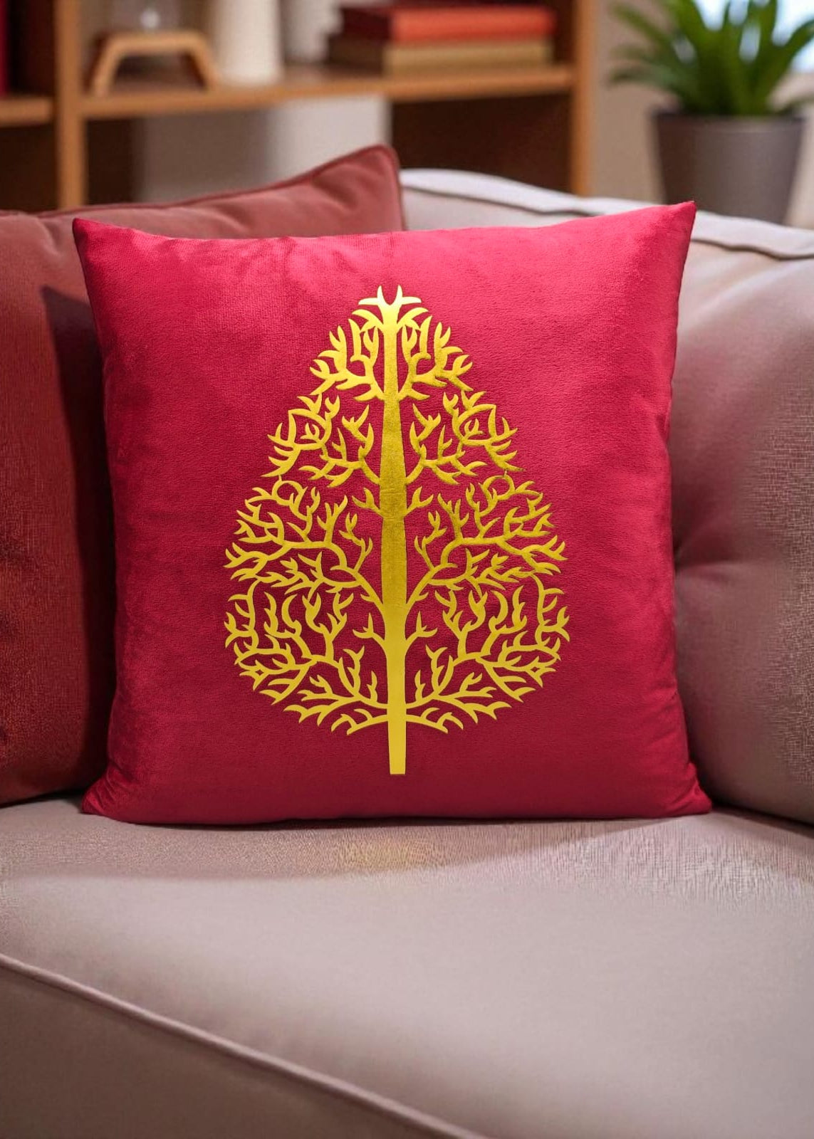 Red pillow with a yellow tree design on a beige couch