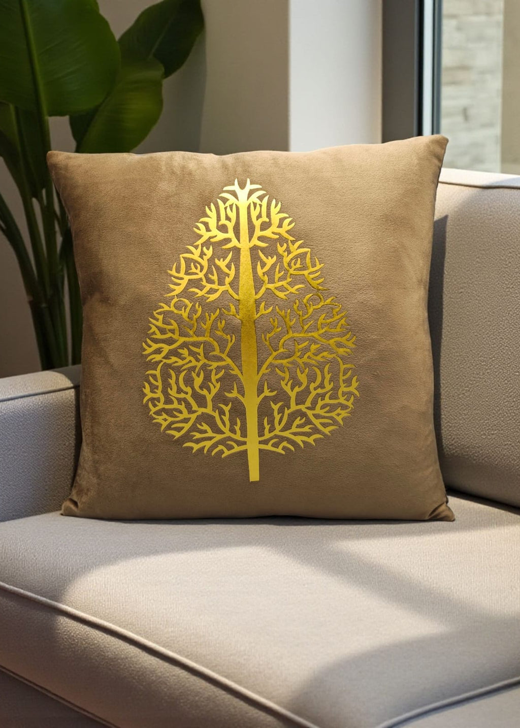 Beige pillow with a yellow tree design on a beige couch