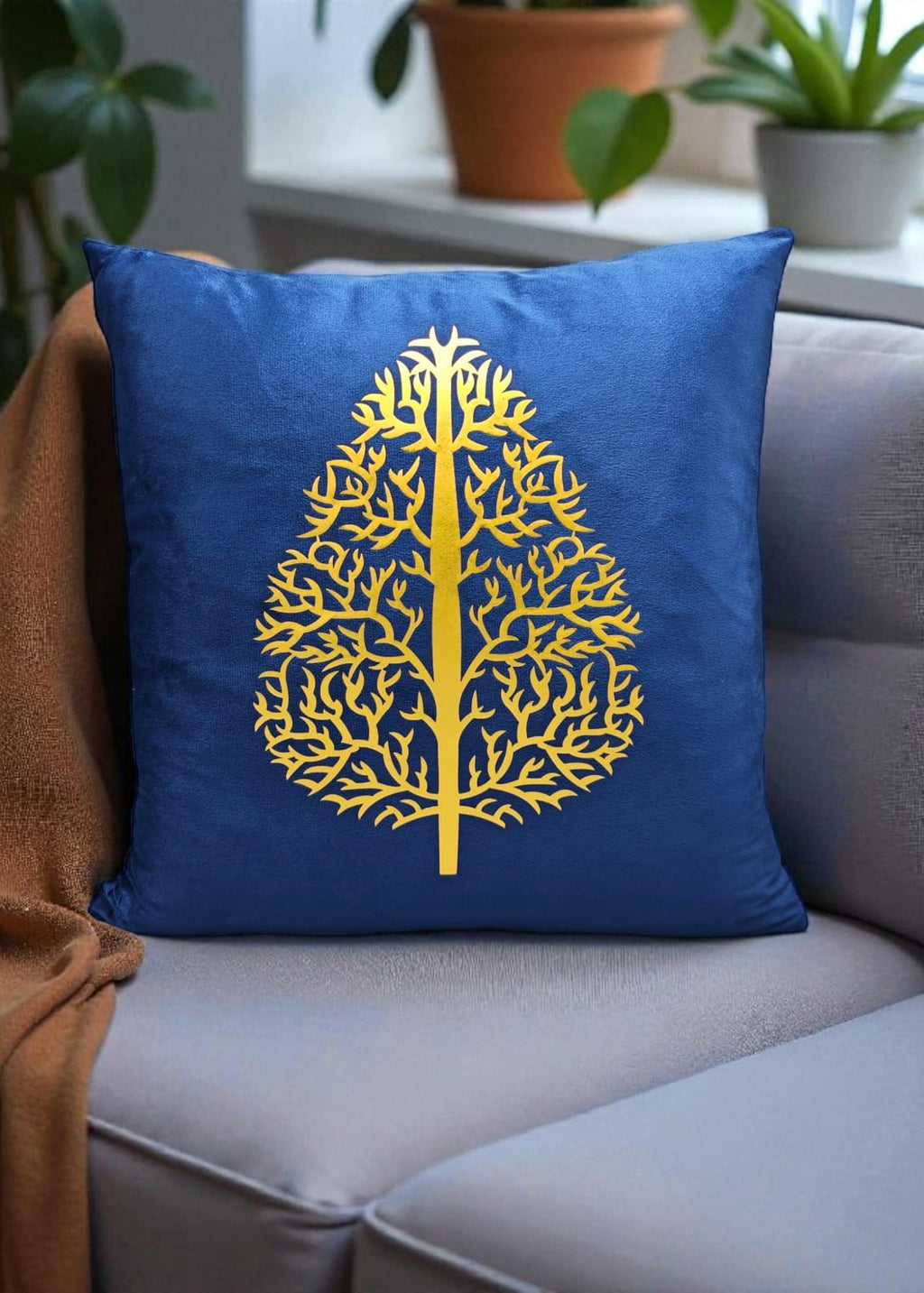 Blue pillow with a yellow tree design on a gray couch