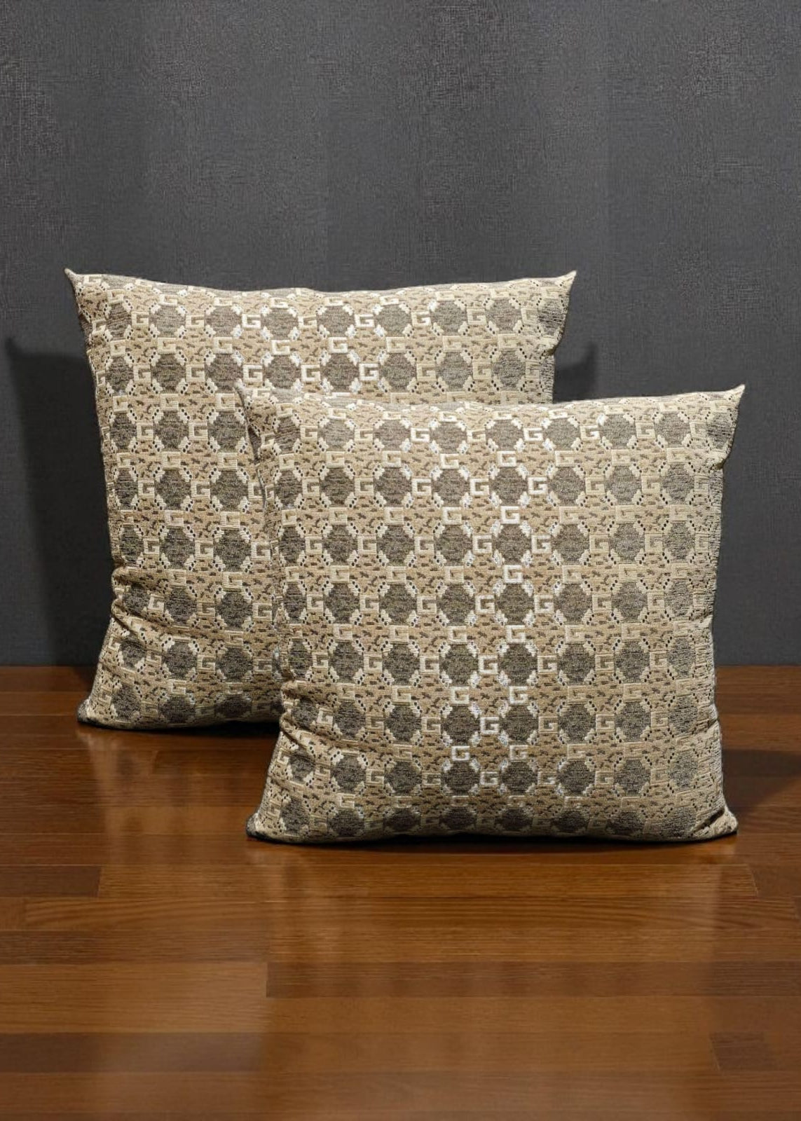 Two patterned pillows on a wooden surface with a dark gray background