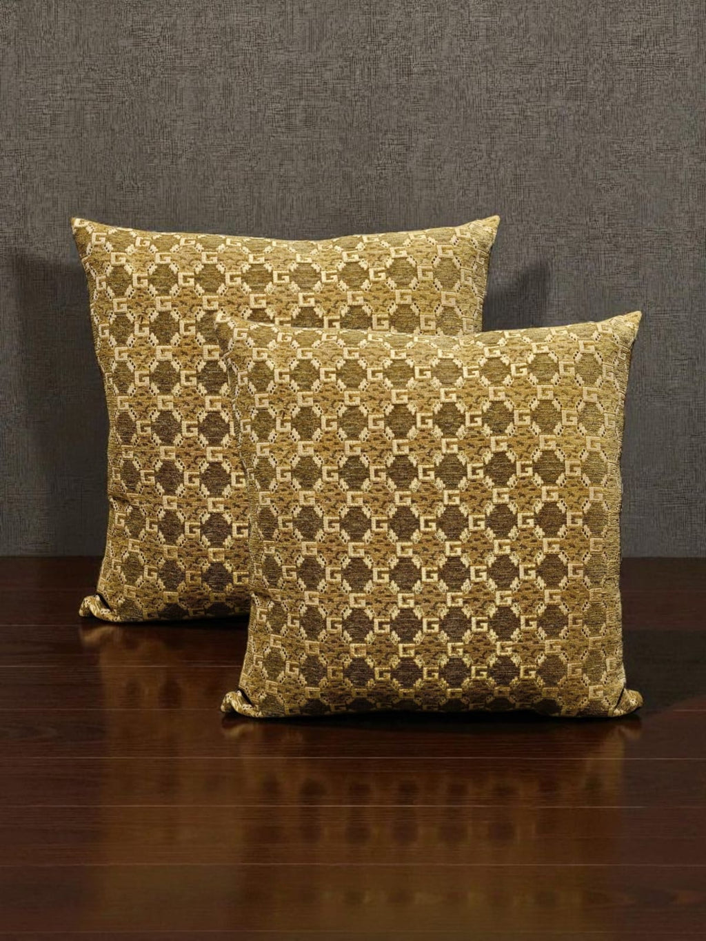 Two patterned pillows on a wooden surface with a dark background