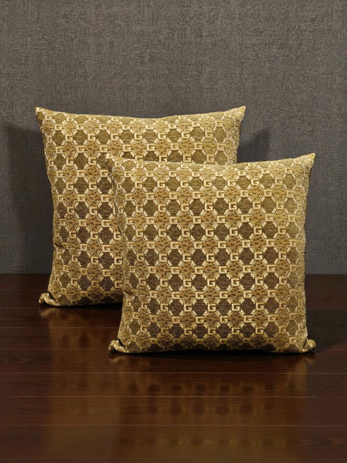 Two patterned pillows on a wooden surface with a dark background